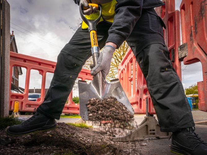 Person using a Roughneck Micro Square Shovel to dig and move soil.