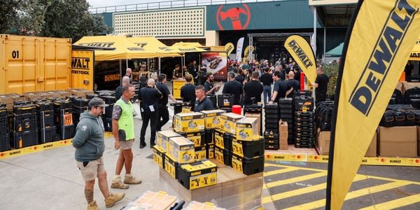 DeWALT event area with branded tents, tool displays and trade customers gathered outside a Bunnings Trade warehouse.