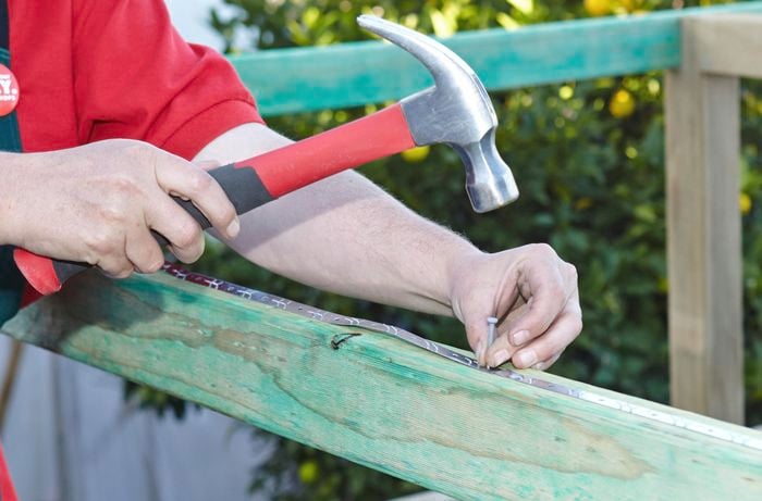 Fix strips being attached to a wooden frame with nails and a hammer