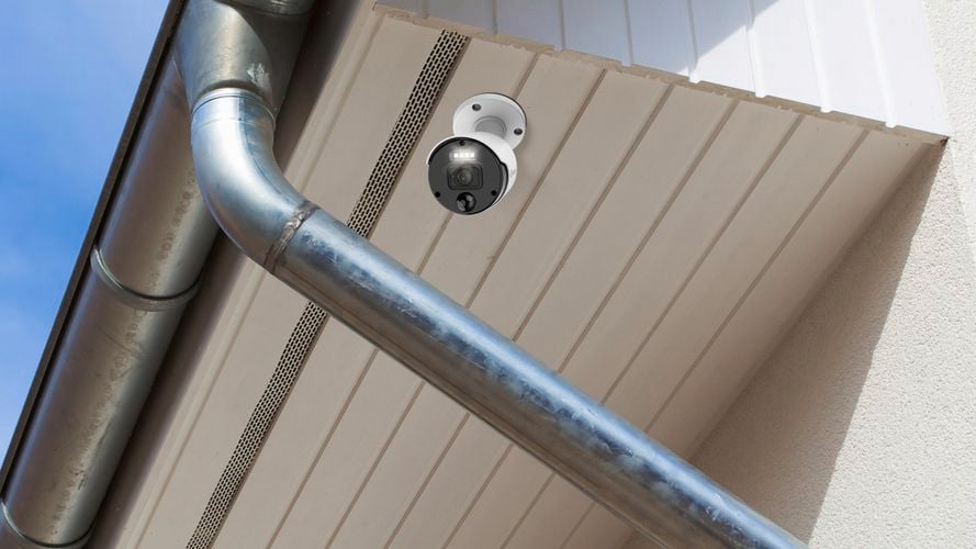 Security camera under the eave of a house exterior