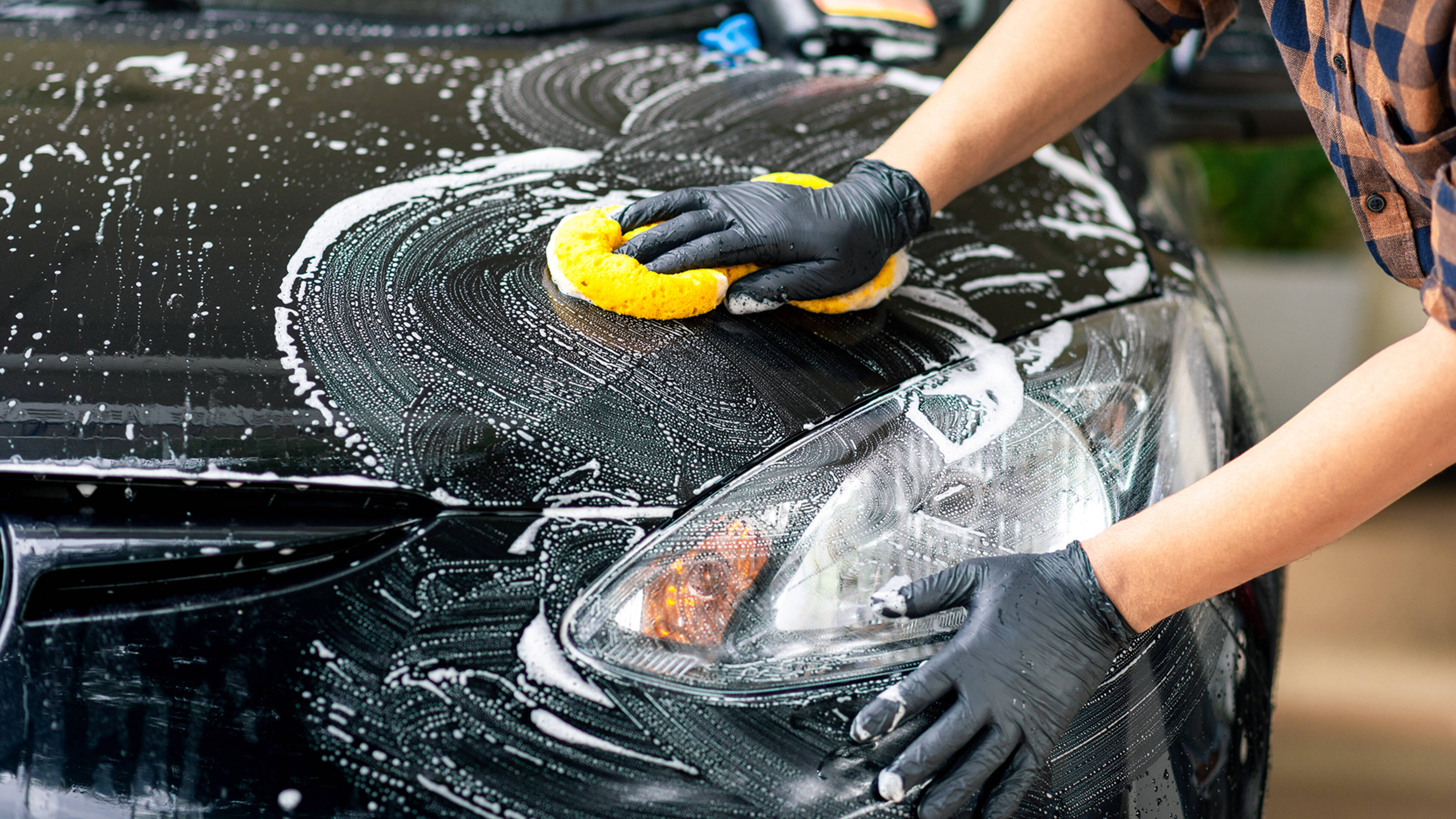 cleaning car exterior with sponge and soap after journey completion