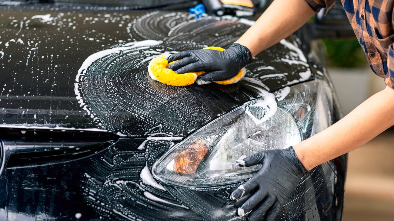 cleaning car exterior with sponge and soap after journey completion