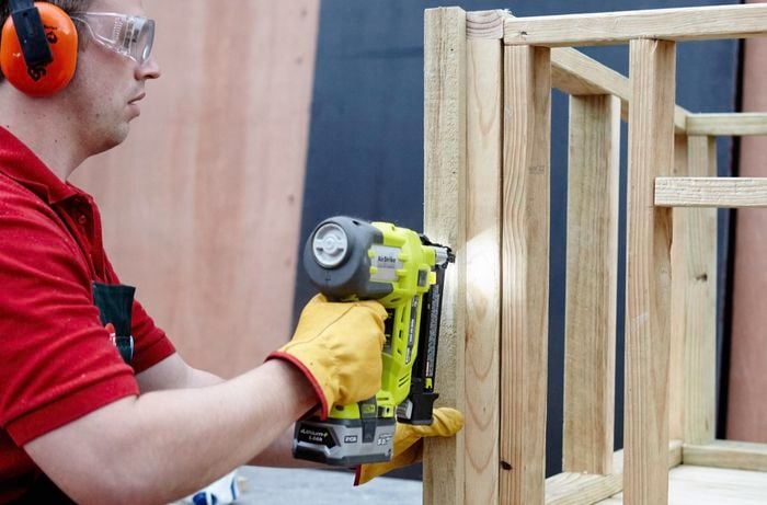 Person drilling timber frame pieces together.