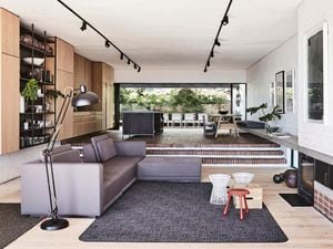 Living room with sunken lounge and long strips of pendant lighting.