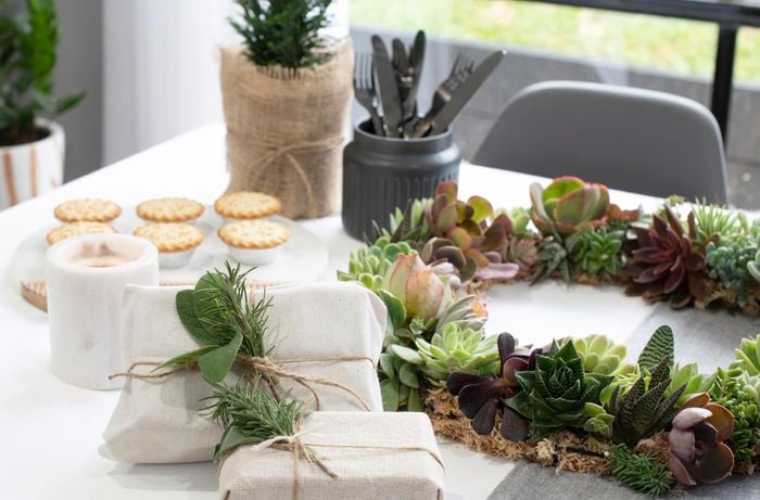 Table with food, presents and succulent wreath on it.