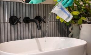 A person pouring liquid into a white basin