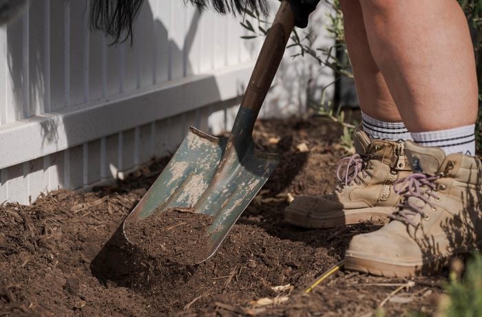A person digging a hole using a shovel.