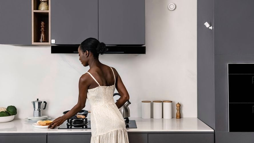 Aqara motion sensor mounted on a kitchen wall above a countertop