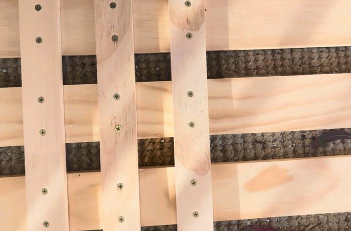 A slatted timber structure lying on carpet