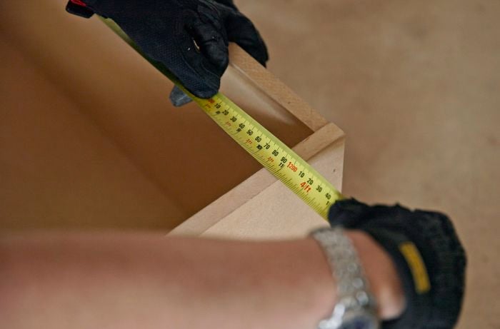 A person measuring the thickness of a kickboard.
