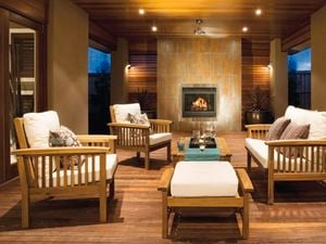 A spacious interior setting with mood lighting, fireplace, couches and timber floors.