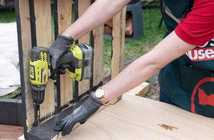Holes being drilled into a painted pallet