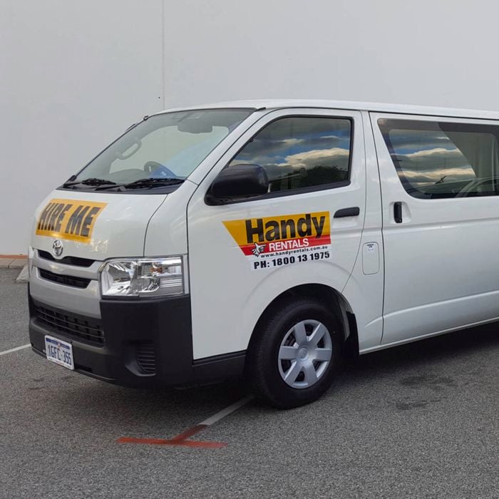 Two Handy Rental vehicles parked next to one another. There is a van on the left and a ute on the right.
