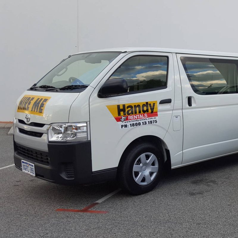Two Handy Rental vehicles parked next to one another. There is a van on the left and a ute on the right.