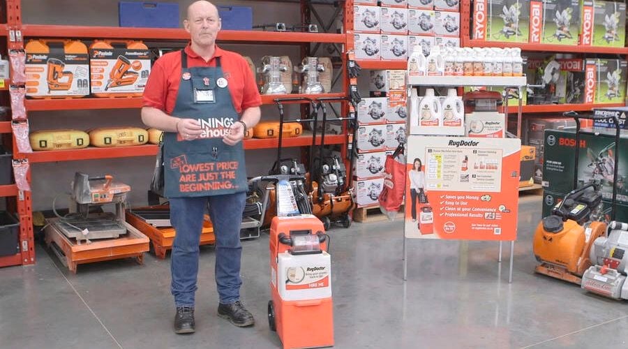 Rug Doctors carpet cleaner with a Bunnings team member standing beside the machine