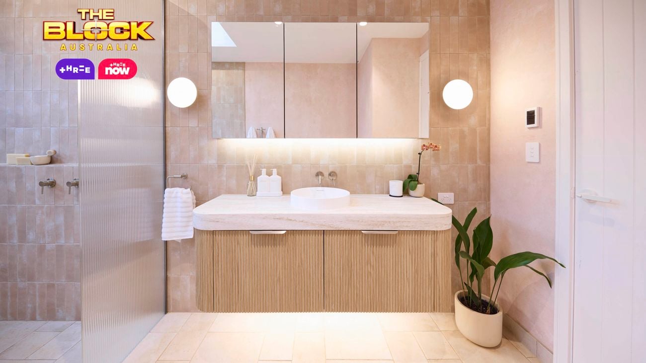 Natural coloured bathroom with a vanity, mirrors, lights on the wall and tiles on the floor in it.