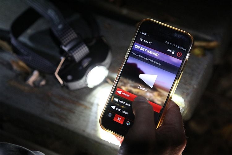 Person adjusting brightness of headlight with mobile app