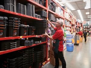 Bunnings team member picking up storage containers.