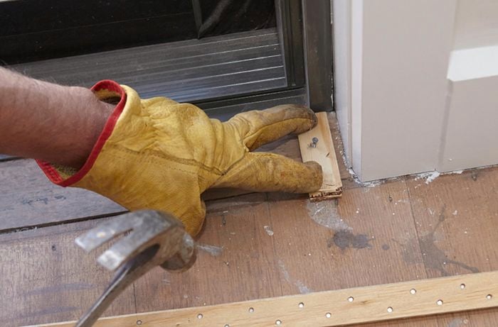 A perimeter being nailed down to subfloor before the laying of carpet