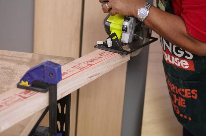 Person using circular saw to cut timber