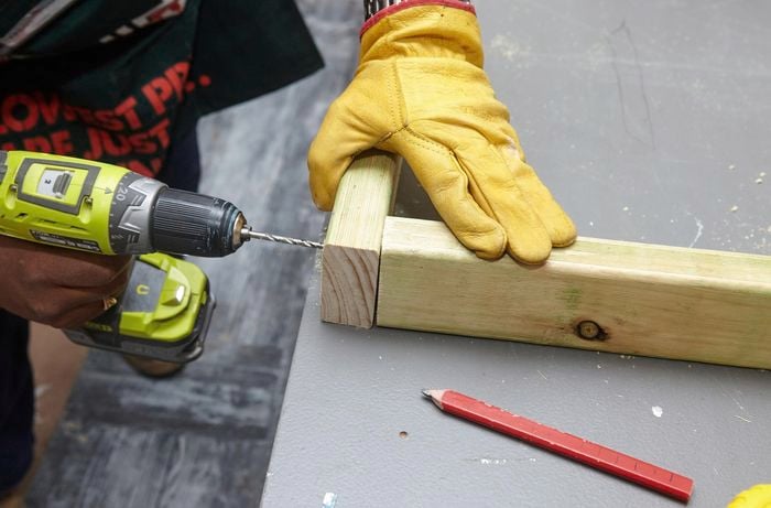 A timber frame being drilled to make way for screws