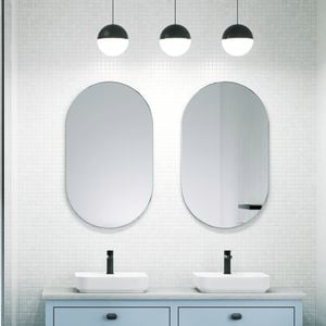A bathroom with 2 mirrors on the wall, 2 basins on a cupboard and a shower