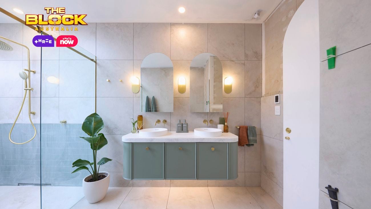 Blue and white bathroom with blue timber vanity, round basins and shower.