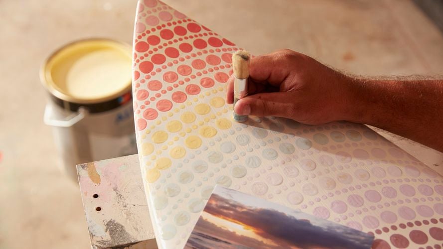 Person paints their surfboard