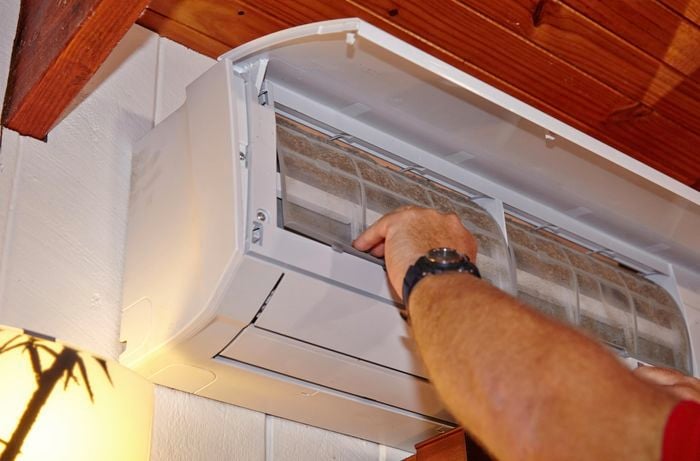 Person removing filters from an air conditioner