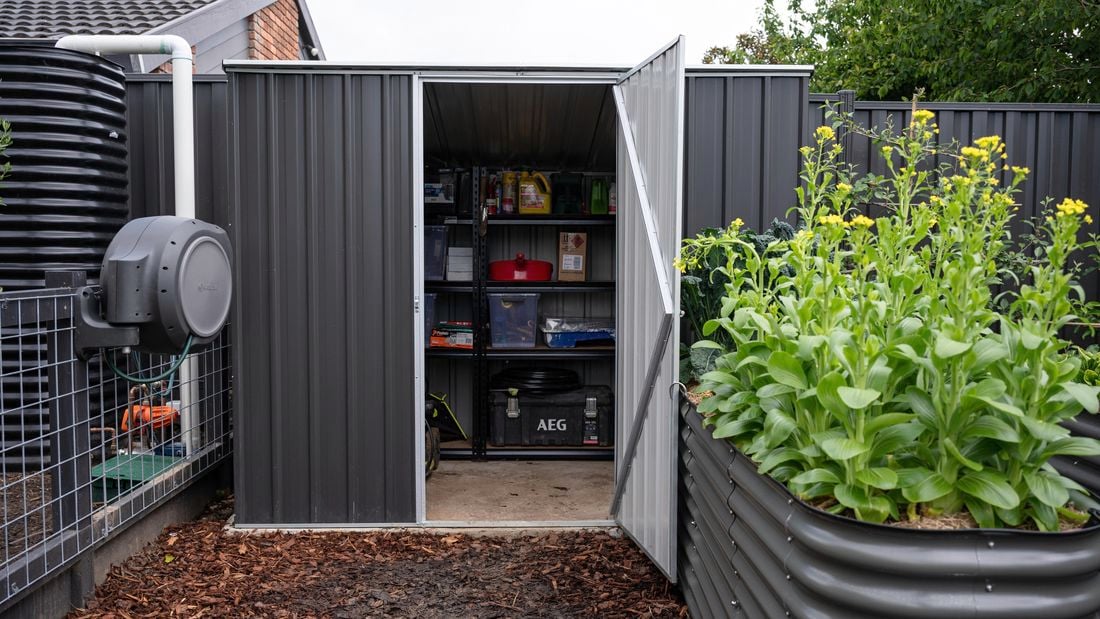 Shed with opened door and organised products on shelving units.