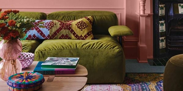 Pink painted room with green couch chairs 