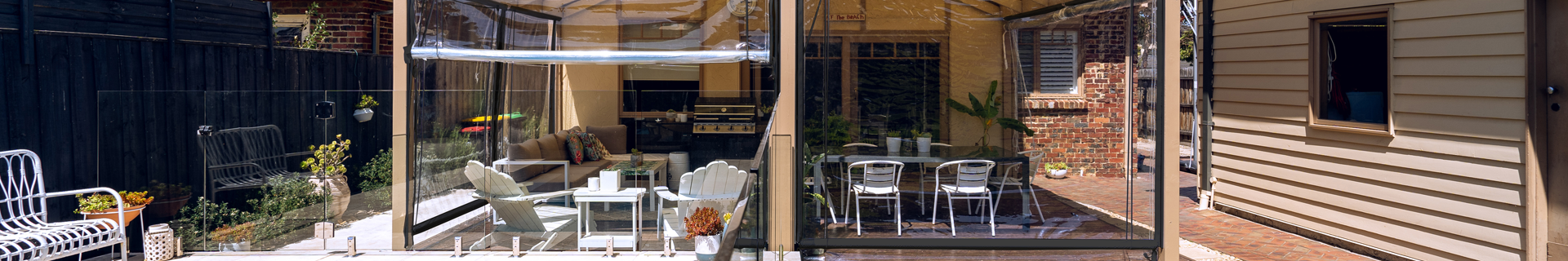 Outdoor entertaining area with clear roller blinds.