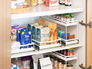 Organised pantry cupboard featuring pull-out storage drawers and shelves