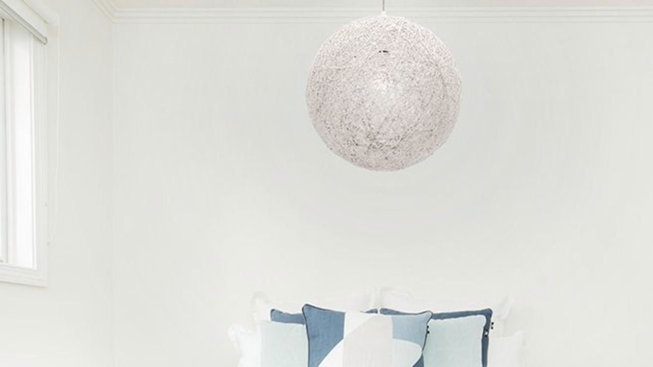 A spherical pendant light hanging in a bedroom.