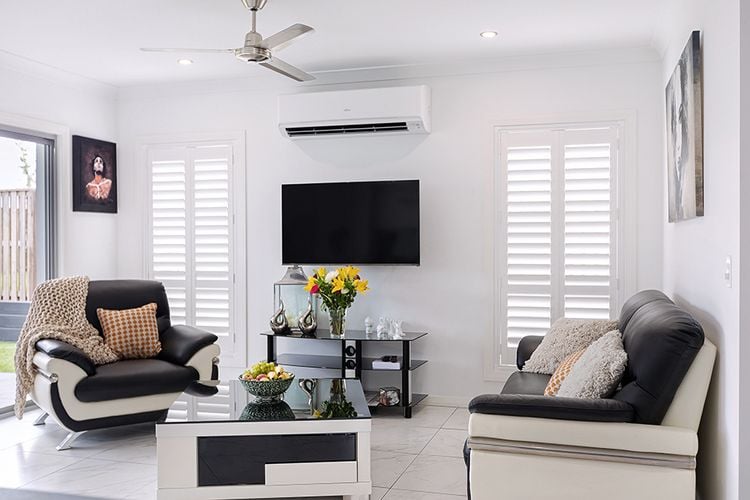 A white themed lounge area with window blinds