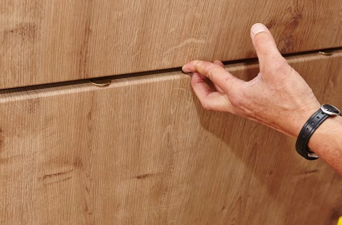 Person sliding drawer into cabinet