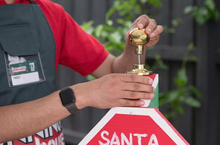 Attaching a brass door knob to the top of the post