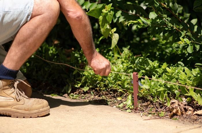 Holding twine laid around the garden.