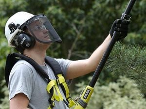 A man wearing a face shield and ear muffs working outdoors
