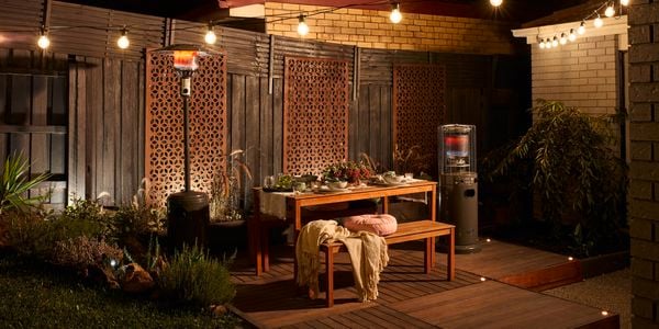 Back garden with outdoor heater, bench seats and beautiful outdoor lighting.