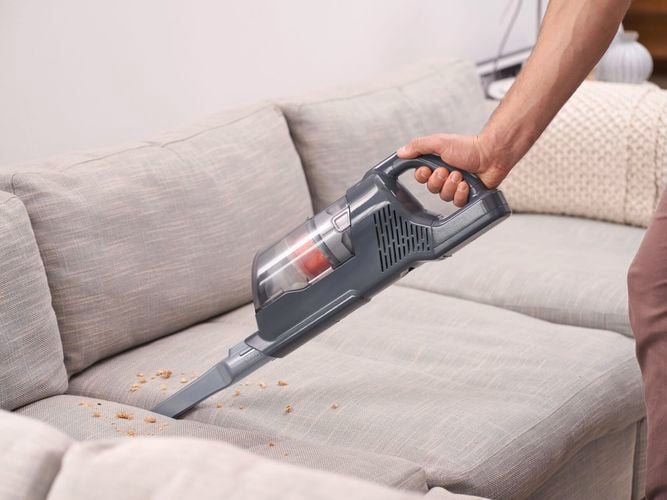 couch being cleaned with black and decker vac