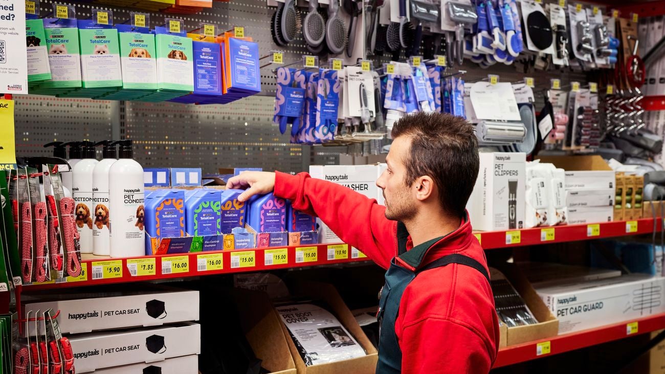 Bunnings’  employee reaching for a pet care product in a purple container