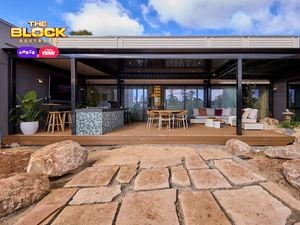 Back of a house with an outdoor setting, lounge and kitchen on decking.
