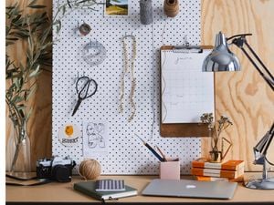 Desk with laptop, lamp and items arranged on a peg board