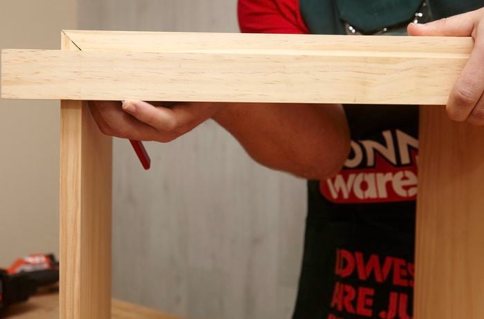 Person marking up timber with pencil.