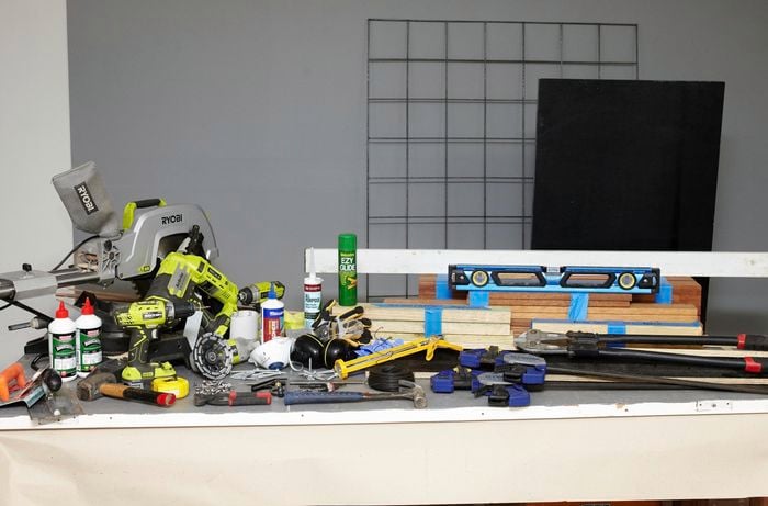 Various tools and materials needed to create a DIY wood and concrete kitchen island.