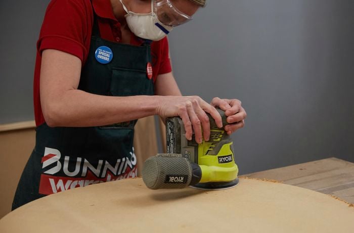 Person using sander to sand timber
