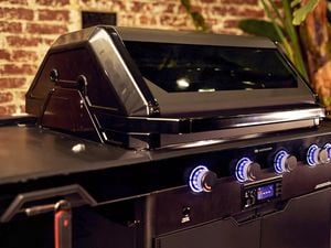 A sleek black barbeque equipped with LED lit control knobs.