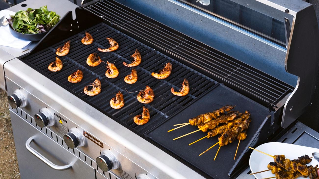 Prawns and chicken skewers cooking on a barbecue grill