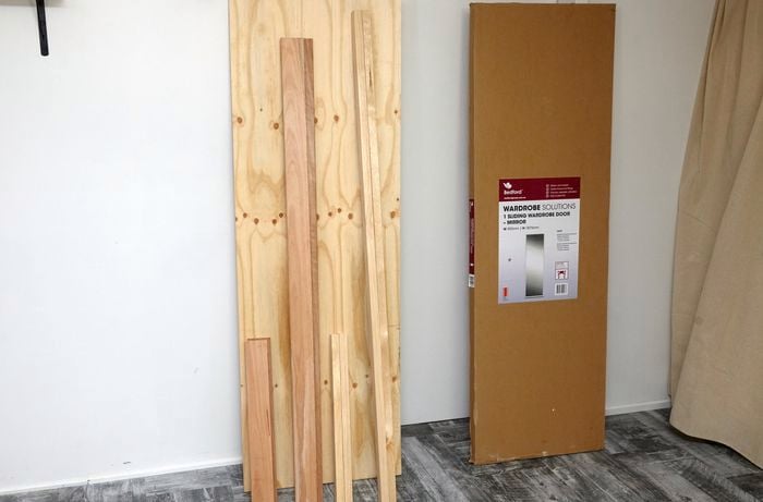 Lengths of timber and plywood and a sliding wardrobe mirror door in packaging
